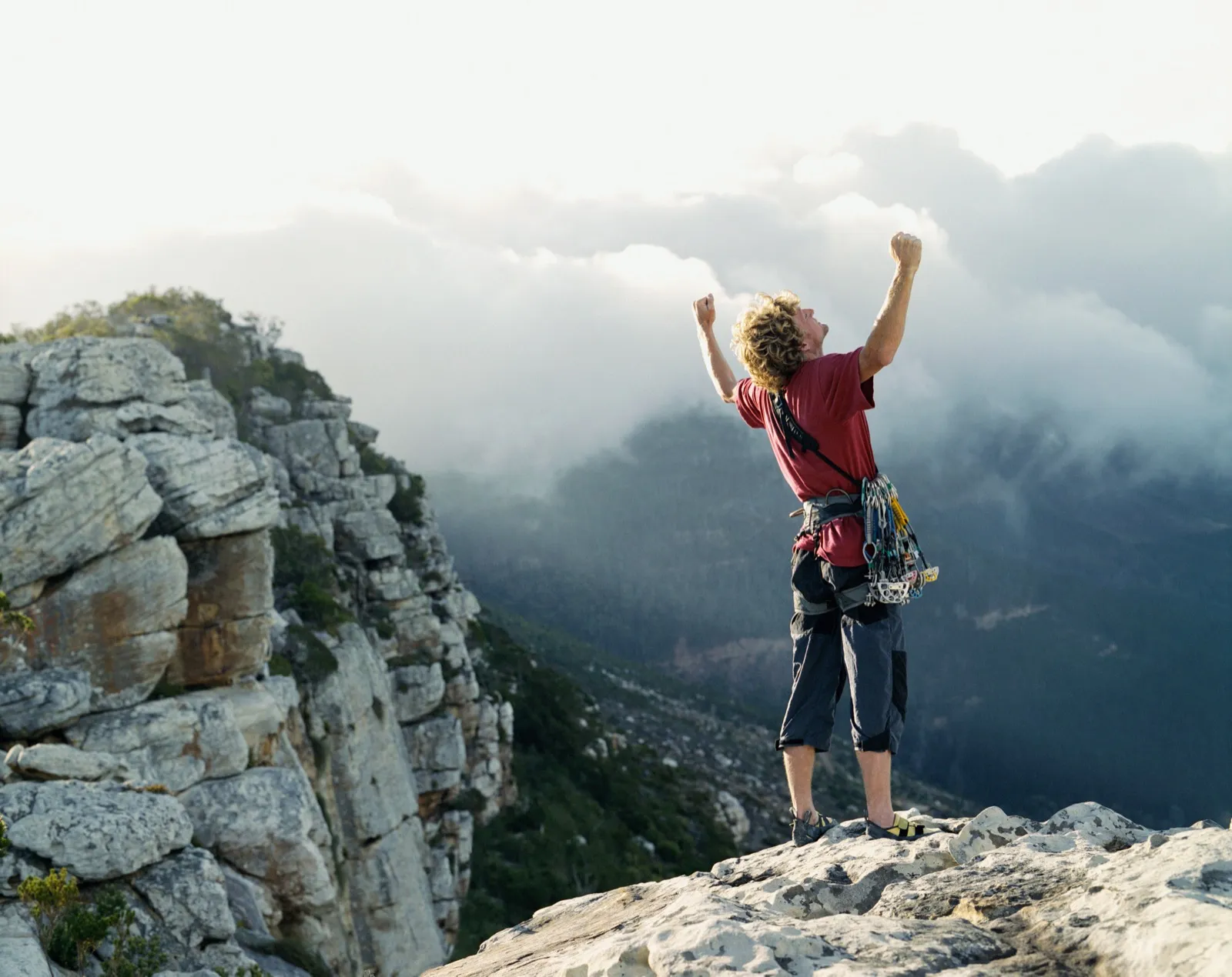 A climber celebrating at the summit after a hard ascent